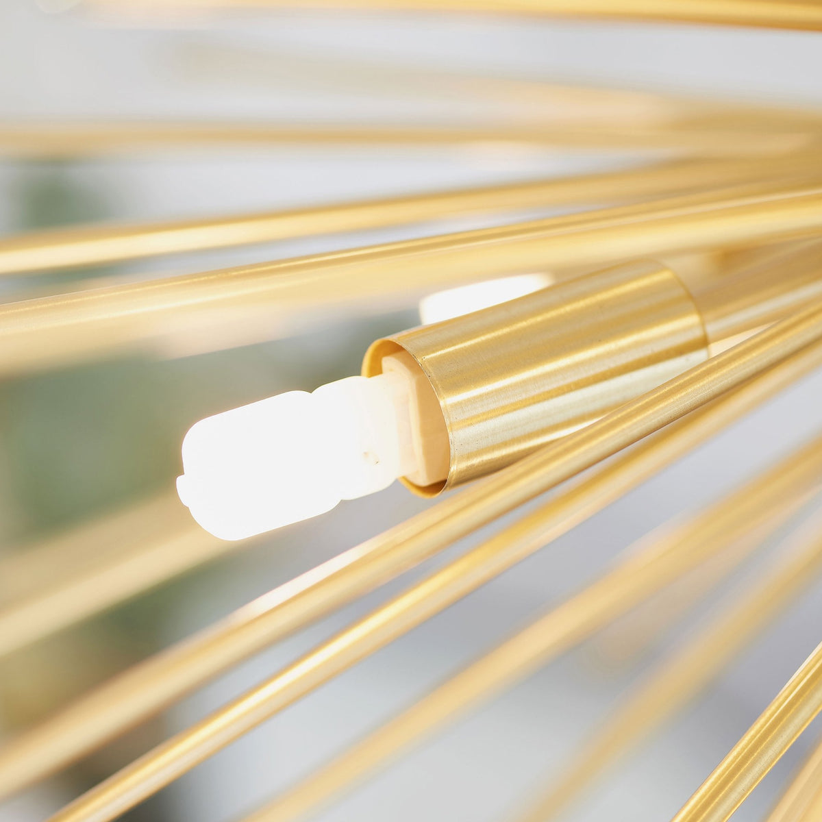 Extreme close-up of a single light bulb and a gold arm from the sputnik chandelier.