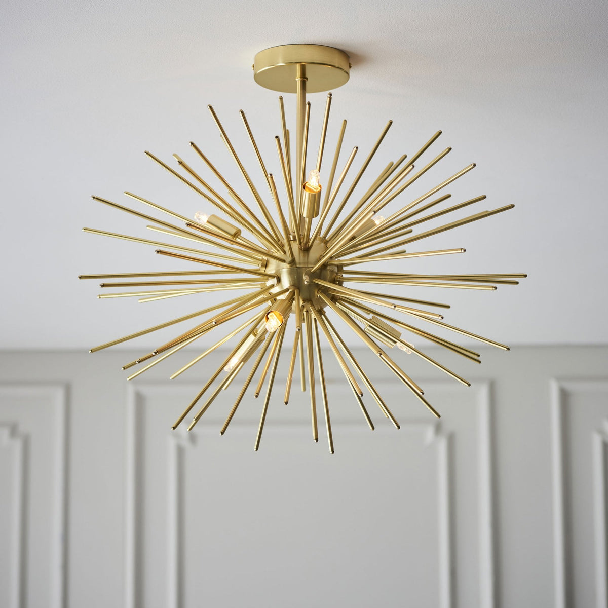 A close-up view of the 12-light Sputnik chandelier in a bright gold finish, capturing its starburst design.
