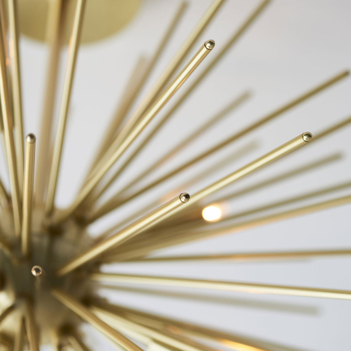 A detailed shot of the gold Sputnik chandelier, highlighting the individual rods and light fixtures.