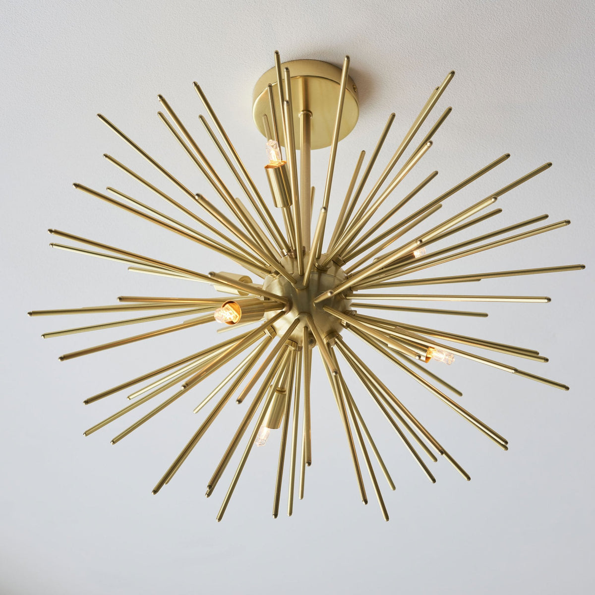 The Sputnik chandelier from a slightly elevated angle, demonstrating its radiant gold finish and design.