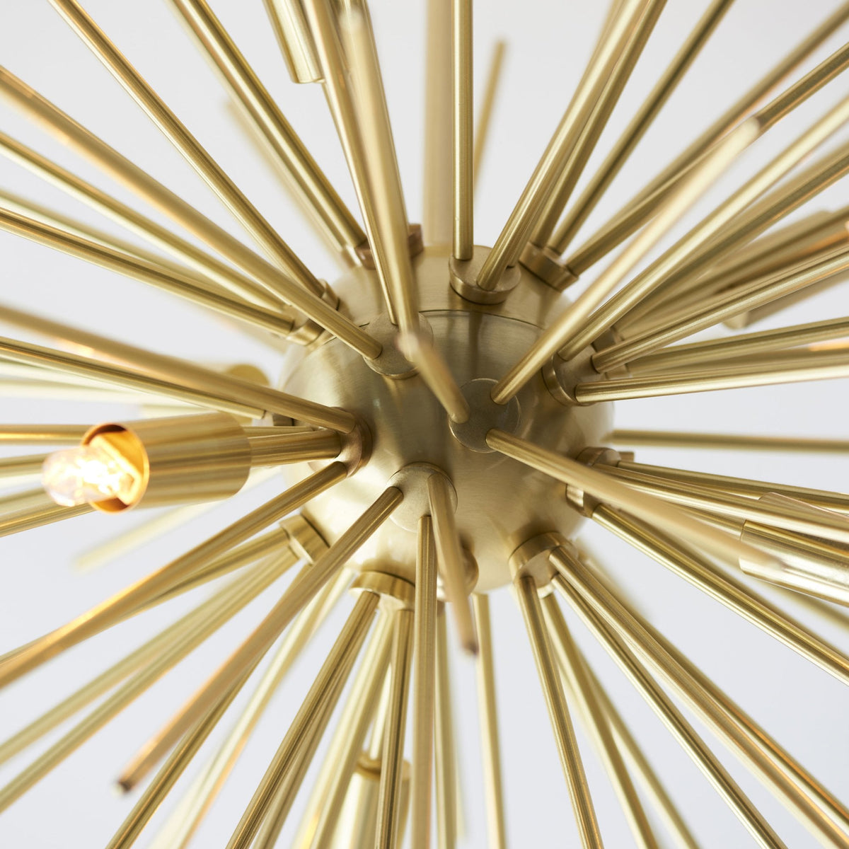 A close-up of the Sputnik chandelier's central sphere, with golden rods radiating outwards.