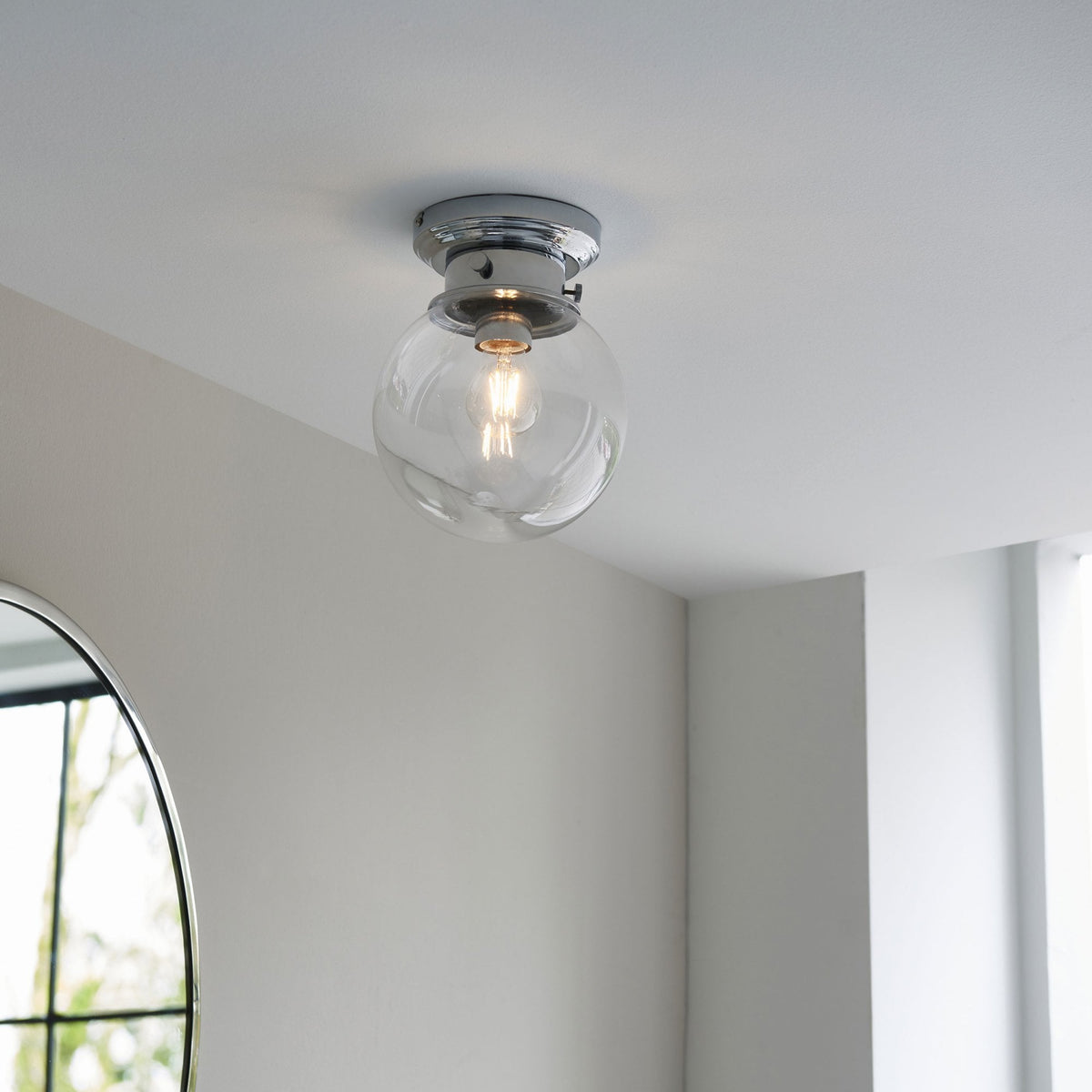 A flush mount ceiling light with a clear globe shade illuminating a modern room.