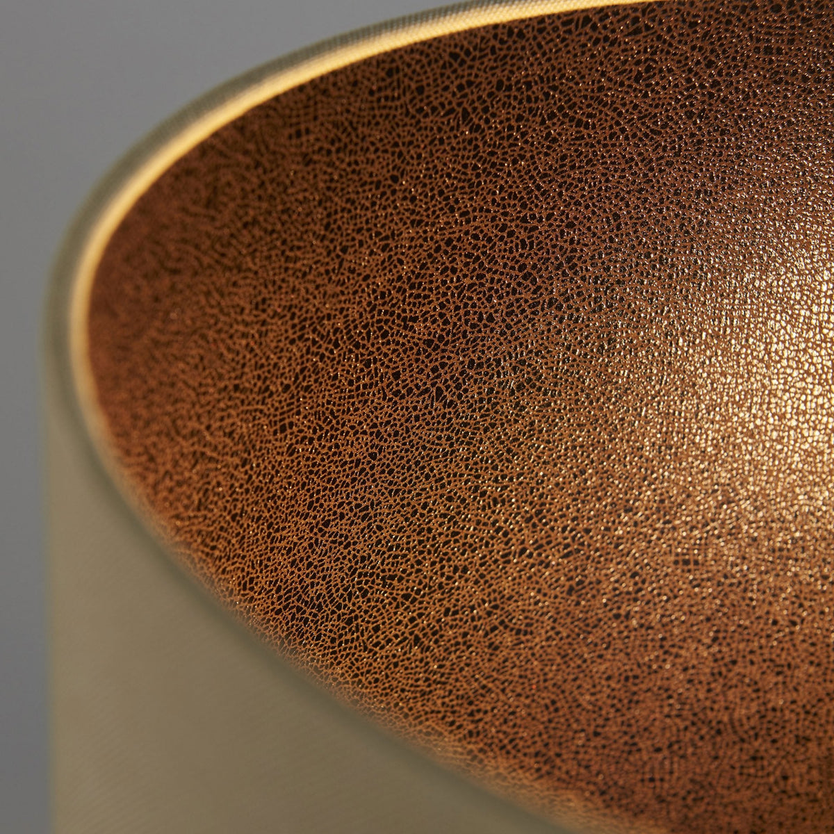 A close-up view of the inside of the lamp shade, showing its textured, metallic bronze lining.