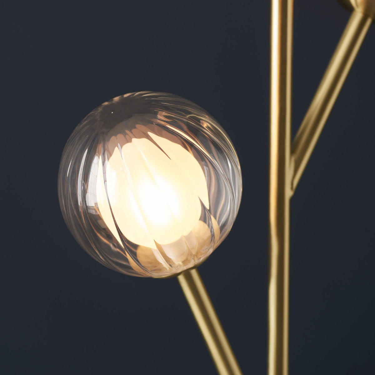Gros plan sur un globe lumineux en verre texturé, révélant la source de lumière chaude à l'intérieur.