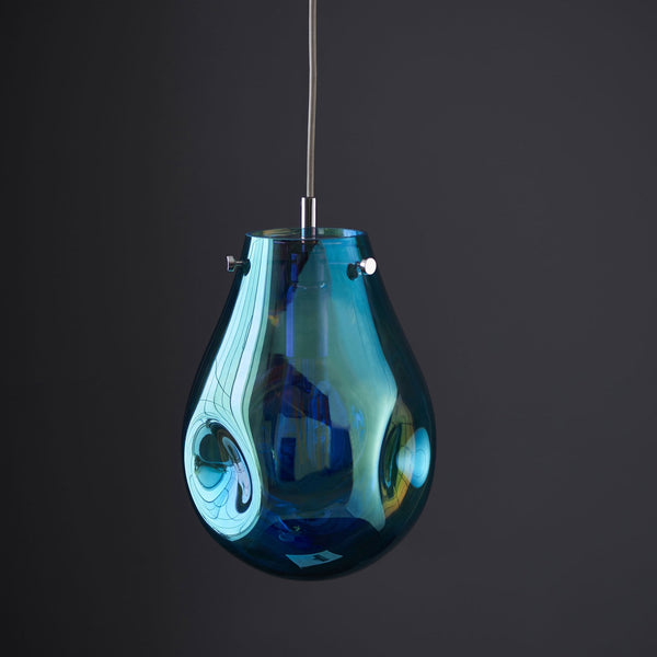 Teardrop pendant light in iridescent blue and amber with an unlit bulb.