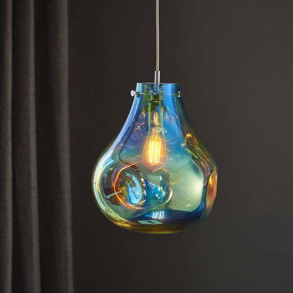 Iridescent glass pendant light, teardrop shape with a visible bulb, against a dark curtain.