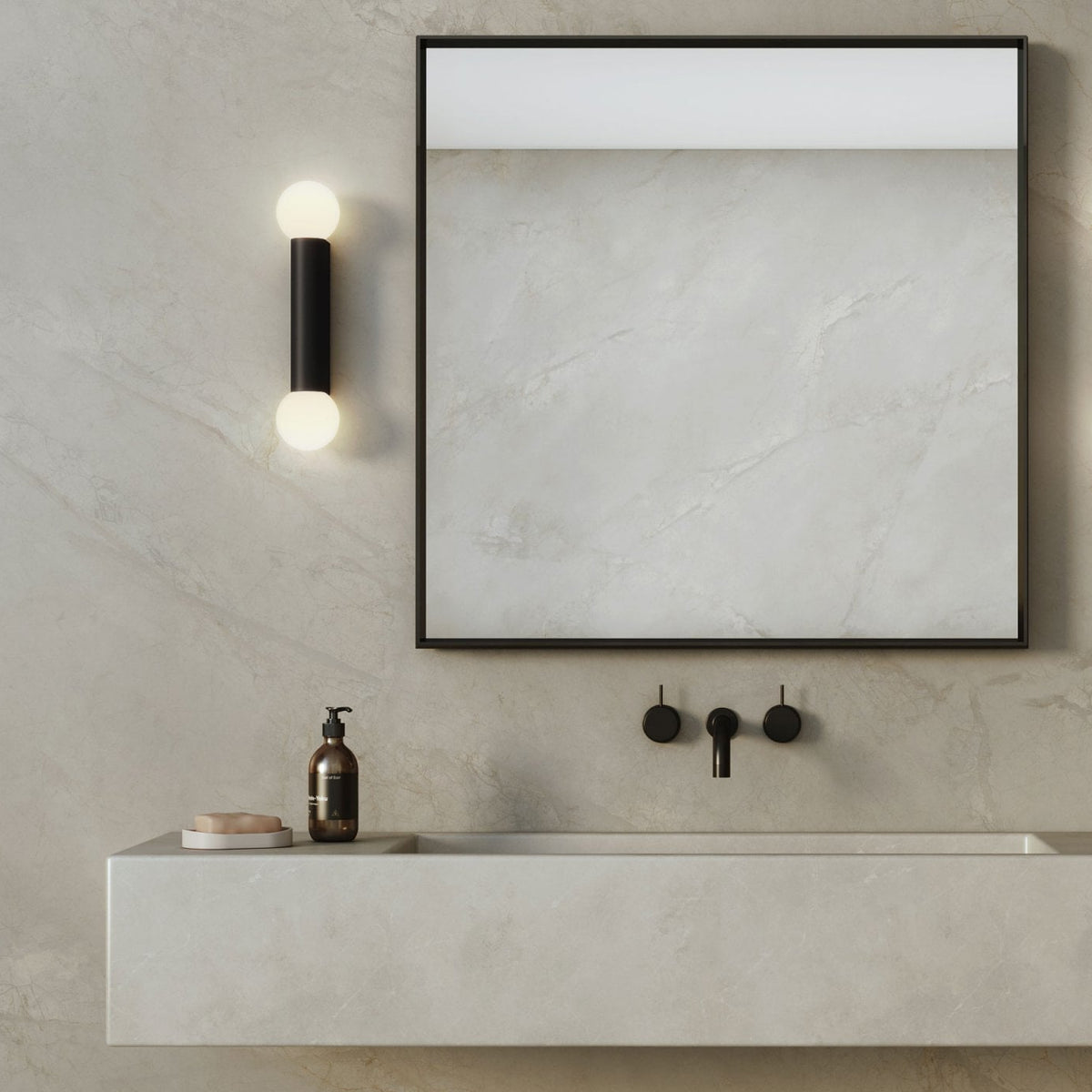 Bathroom vanity with a mirror, wall-mounted faucet, and a black cylindrical light fixture with two bulbs
