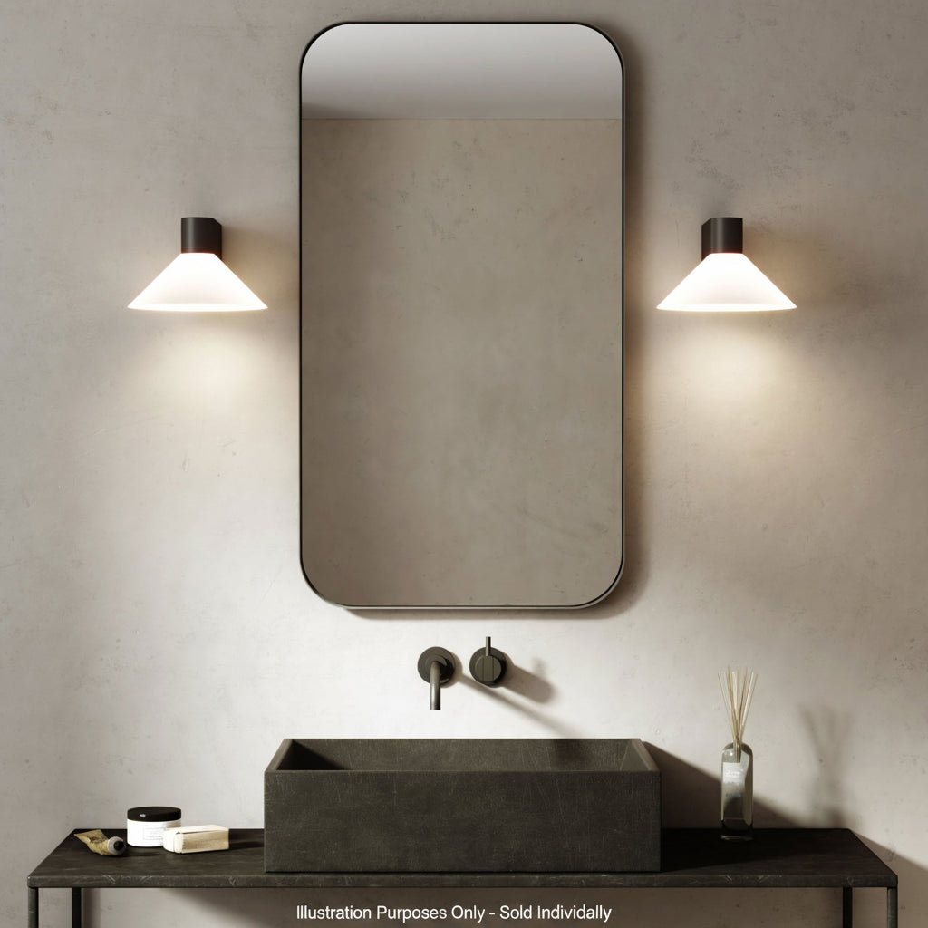 Bathroom vanity with black rectangular sink, black faucet, rectangular mirror, and two wall sconces