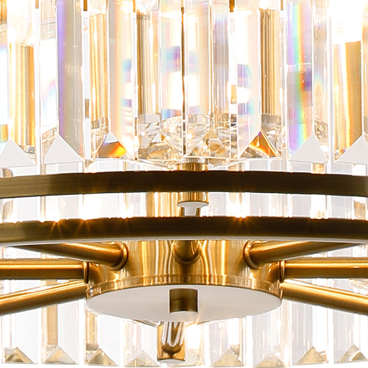 Close-up of a crystal chandelier with brass accents, showing light refracting through the facets.