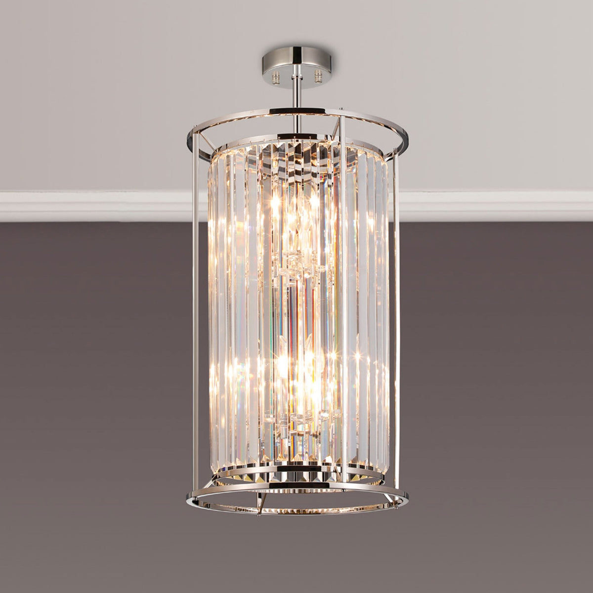Cylindrical crystal chandelier with polished chrome accents, casting sparkling light.