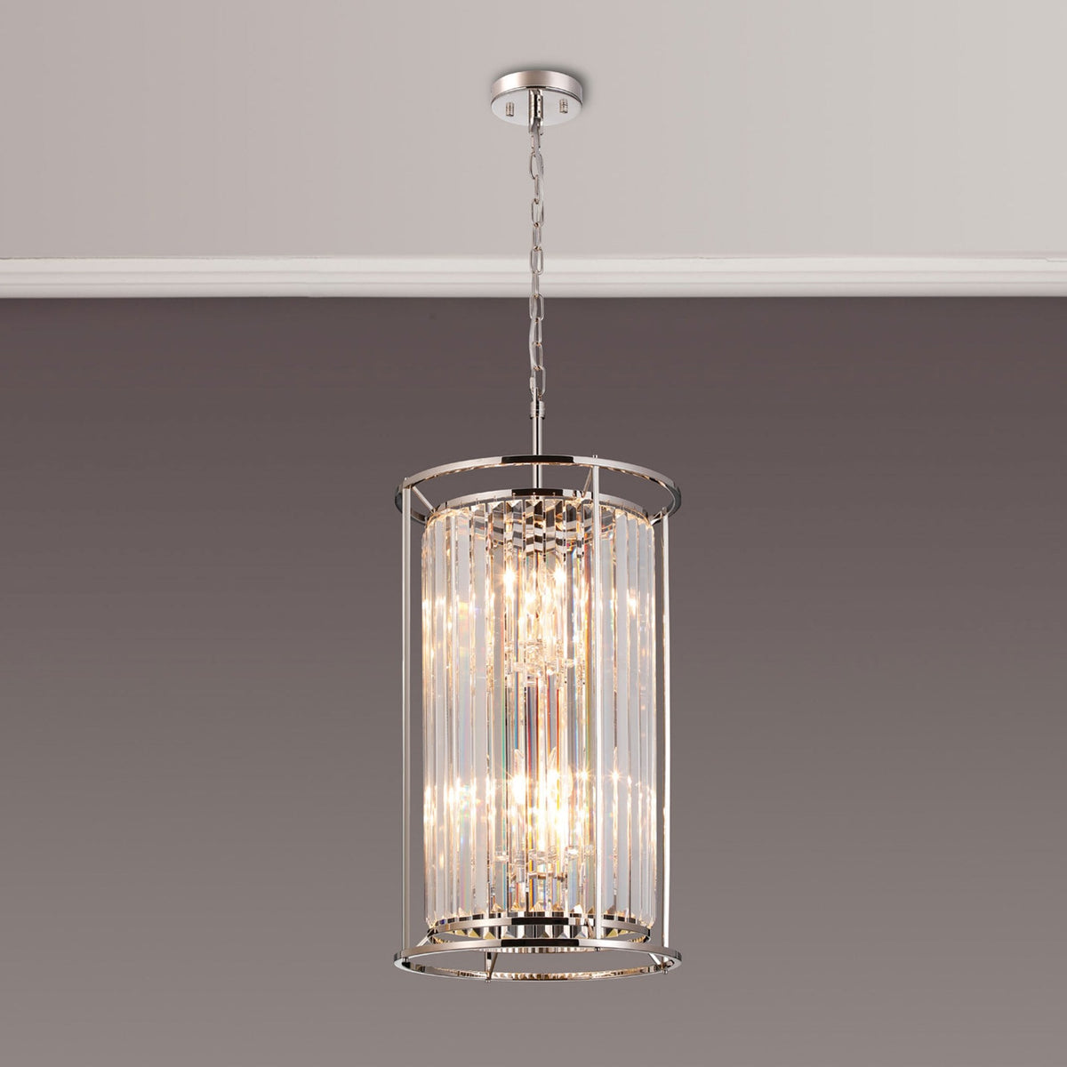 A modern cylindrical chandelier with clear crystal rods and a polished chrome finish, hanging from a ceiling.