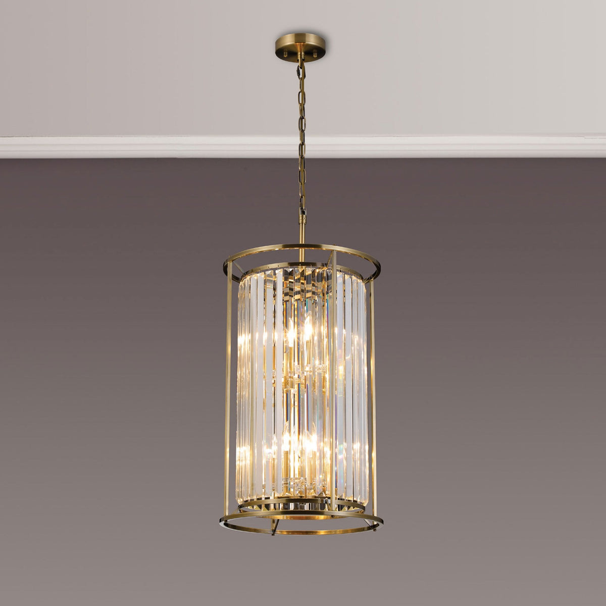 A gold and crystal chandelier hangs from a white ceiling against a gray wall.