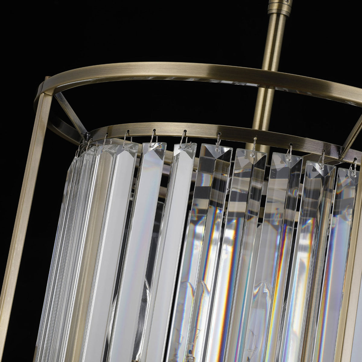 Close-up of a bronze chandelier with rectangular crystal prisms hanging from its frame.