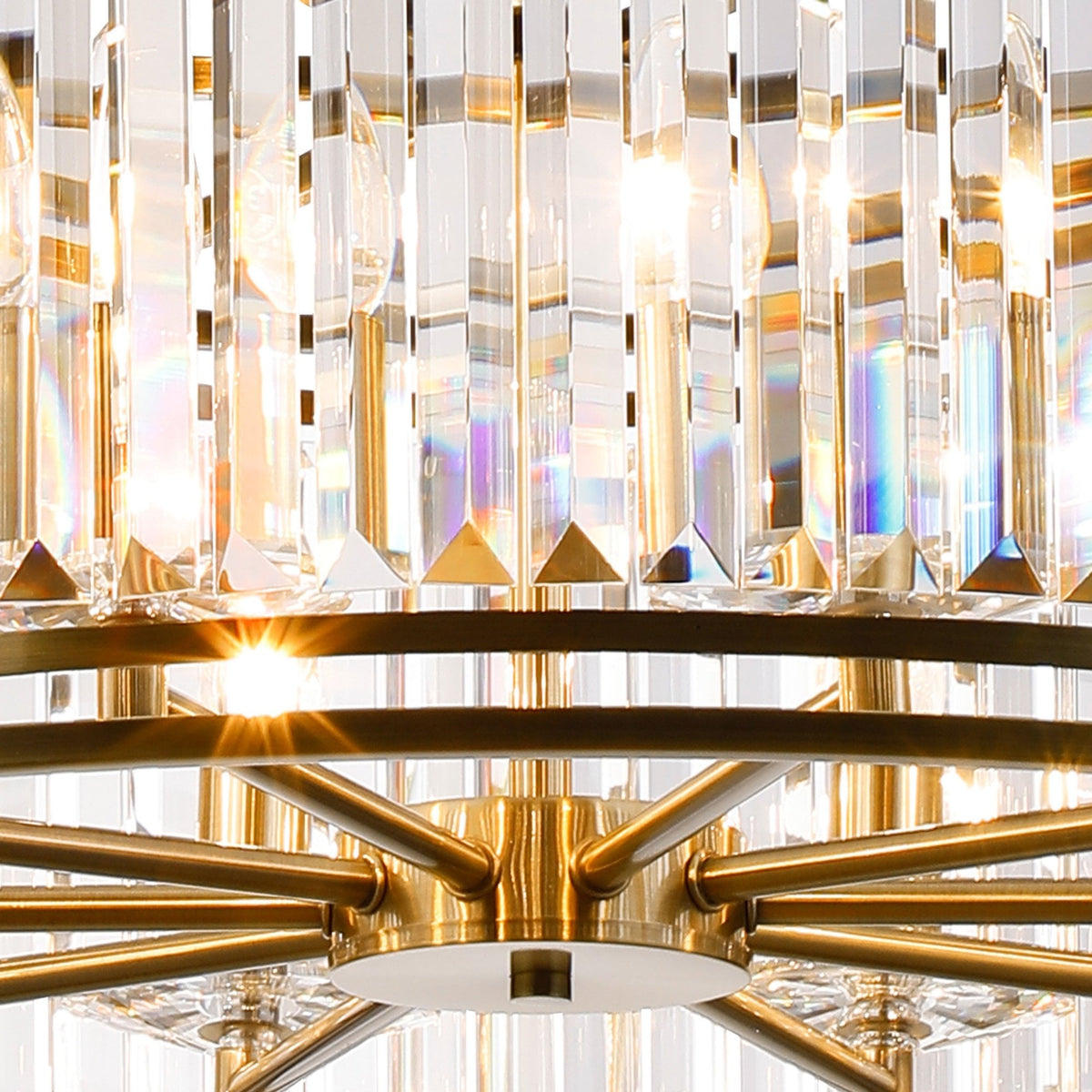Close-up of a crystal chandelier with brass accents, showing light reflecting through the clear prisms.