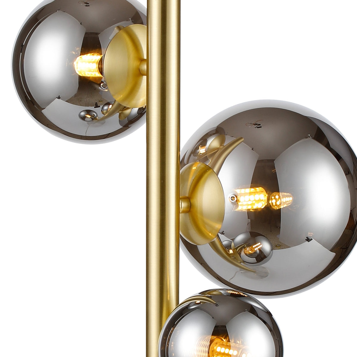 Close up of a gold floor lamp with three smoked glass globes and exposed bulbs