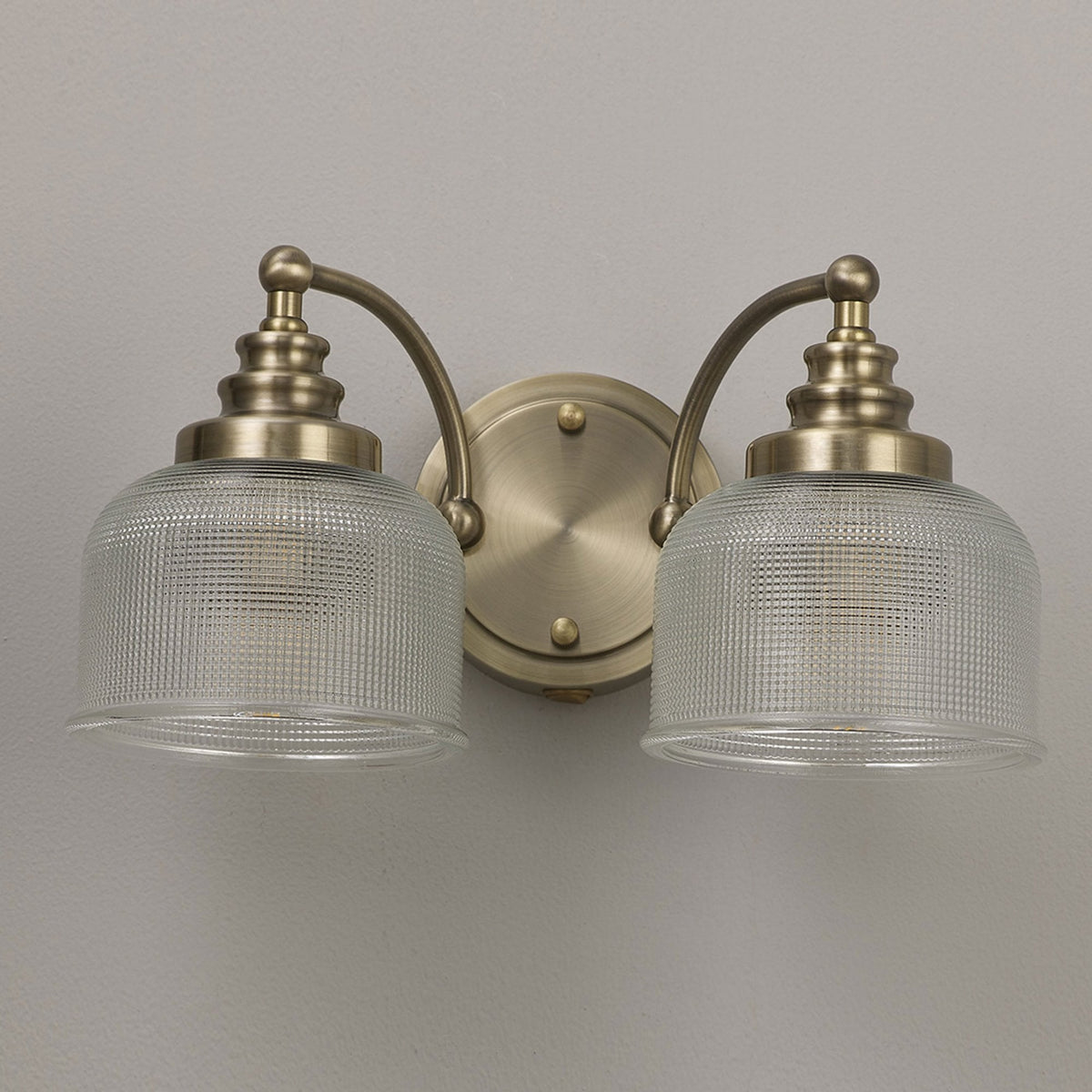 Stowford Switched Twin Wall Light in Antique Brass & Clear Prismatic Glass