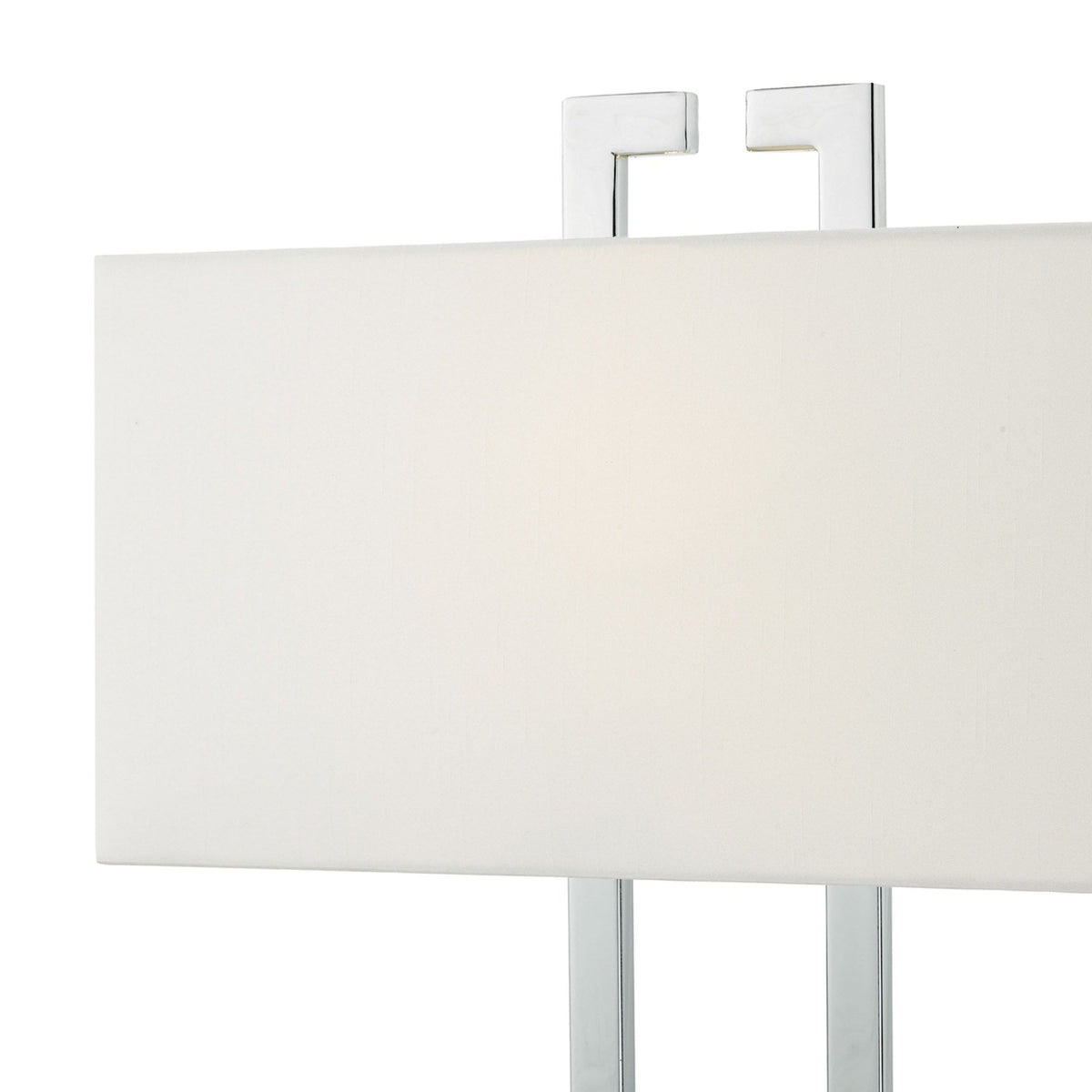 A close-up of a rectangular white lamp shade with a chrome frame.