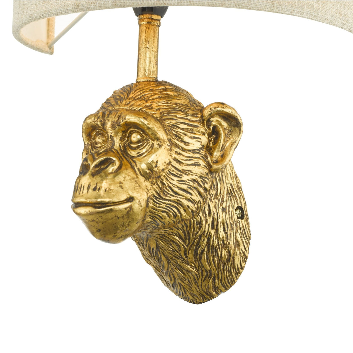 A golden monkey head wall lamp with a light-colored fabric shade.