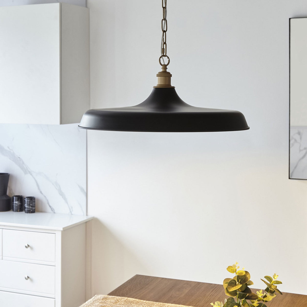 Un luminaire suspendu noir et or avec un design élégant, parfait pour un éclairage d'appoint sophistiqué.