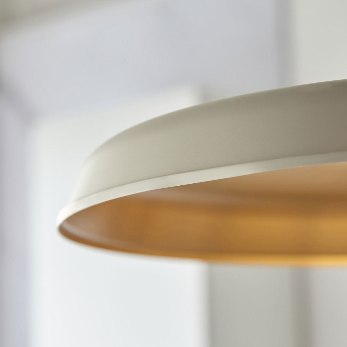 Close-up of the cream-colored pendant light with a gold interior.