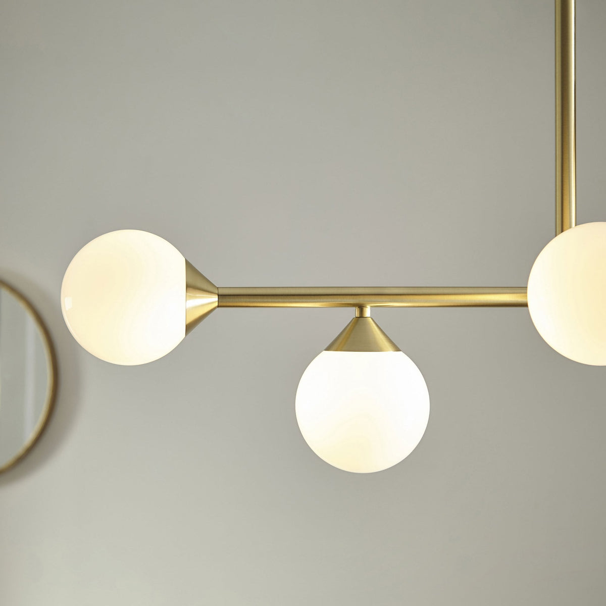 A detailed shot of a brass chandelier's globe lights, highlighting the fixture's elegant and minimalist design.