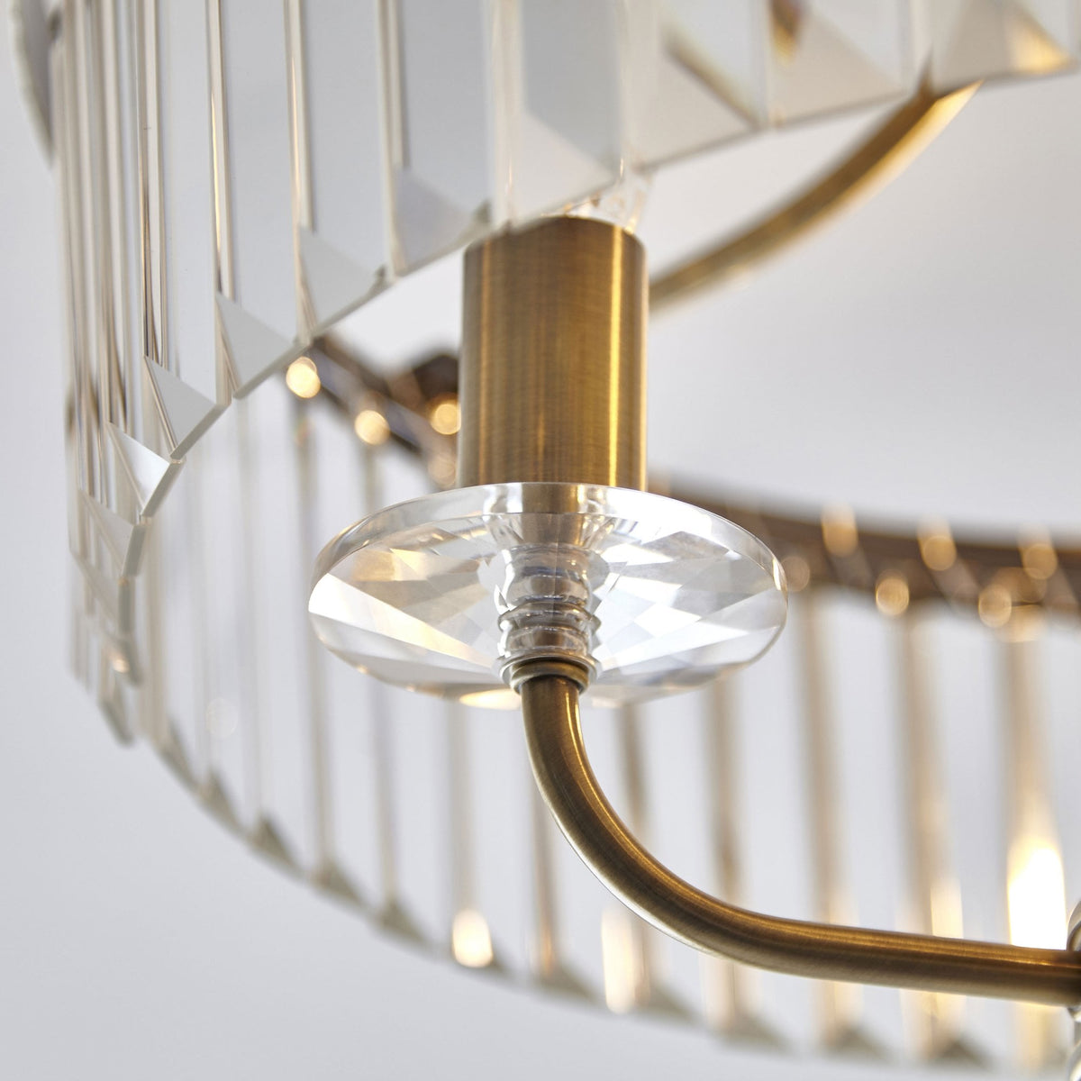 A close-up of the elegant crystal rods and brass details on the Tiffany round semi-flush ceiling light.