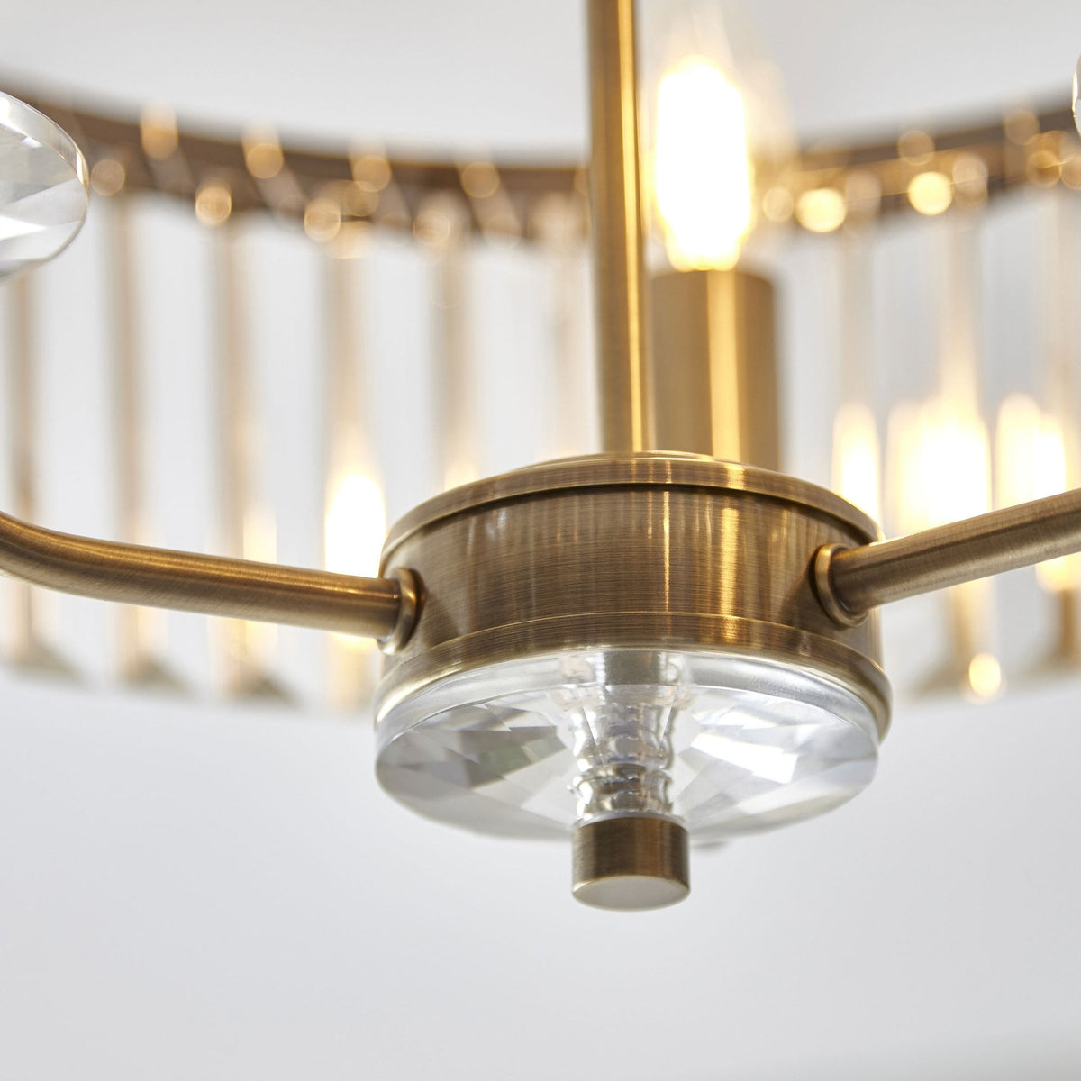 A close-up of the elegant crystal rods and brass details on the Tiffany round semi-flush ceiling light.