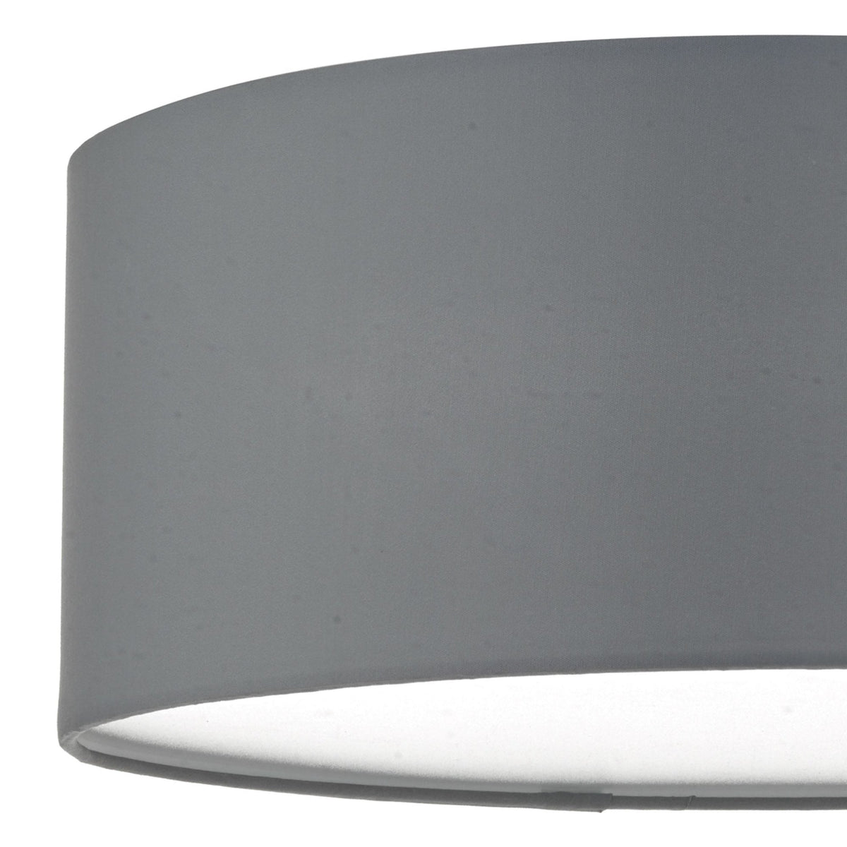 Close-up of a gray fabric lampshade with a white interior, casting a soft glow.