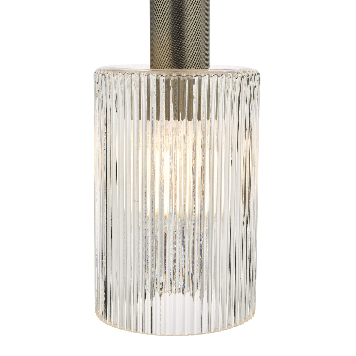 A close-up of a clear, ribbed glass light fixture with a glowing bulb inside and a textured metal top.