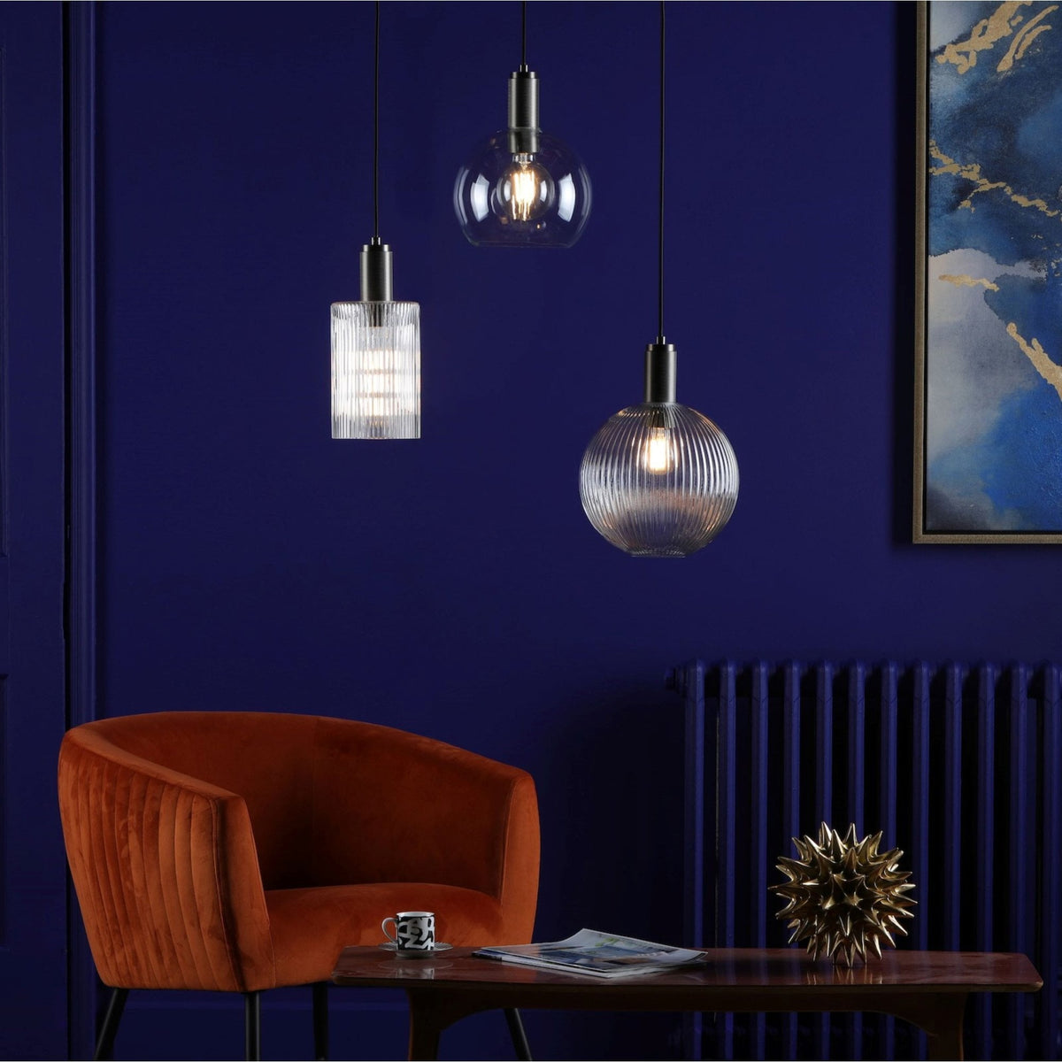 Three pendant lights hang from a dark blue ceiling, illuminating a modern living room.