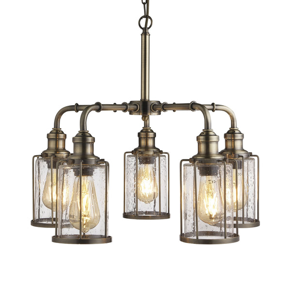 An industrial-style five-light chandelier with clear seeded glass shades and an antique brass finish.