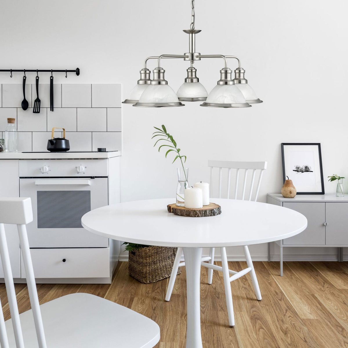 A 4-light brushed nickel chandelier with frosted glass shades hangs in a bright kitchen.
