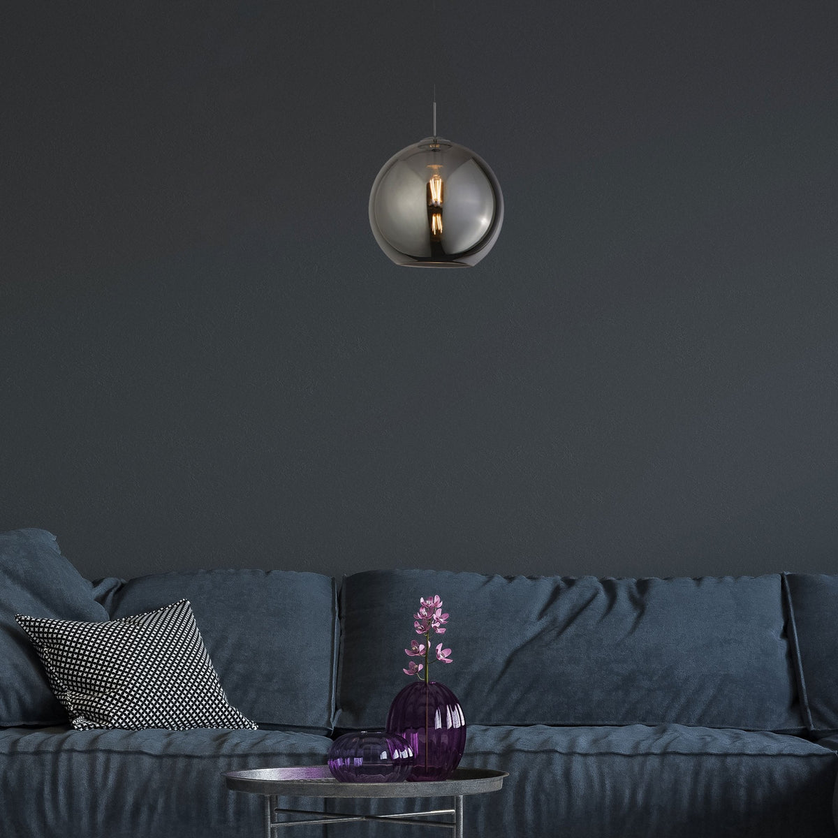 A smoked glass globe pendant light illuminates a modern living room with a blue sofa.