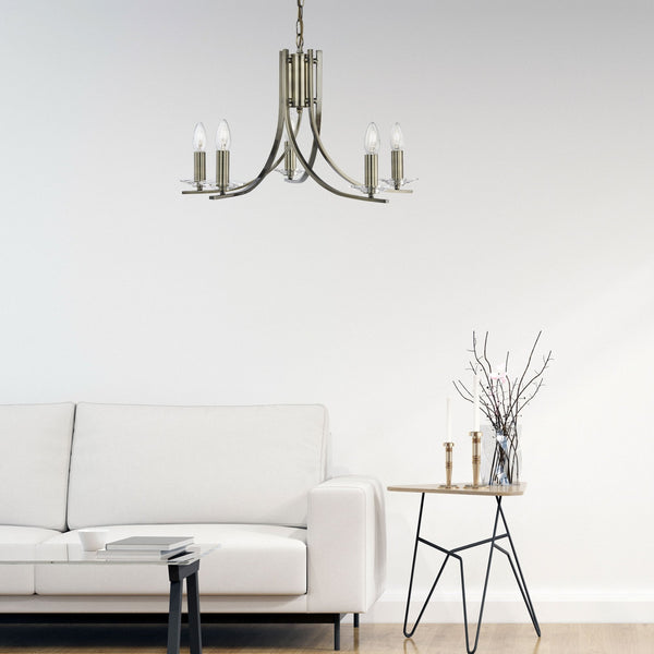 A five-light antique brass chandelier illuminating a modern living room.