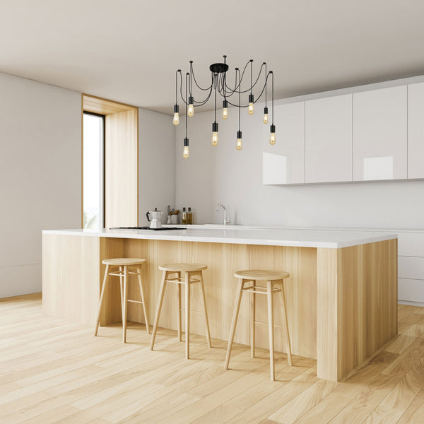 Black 8-light spider pendant lamp with Edison bulbs in a modern kitchen.