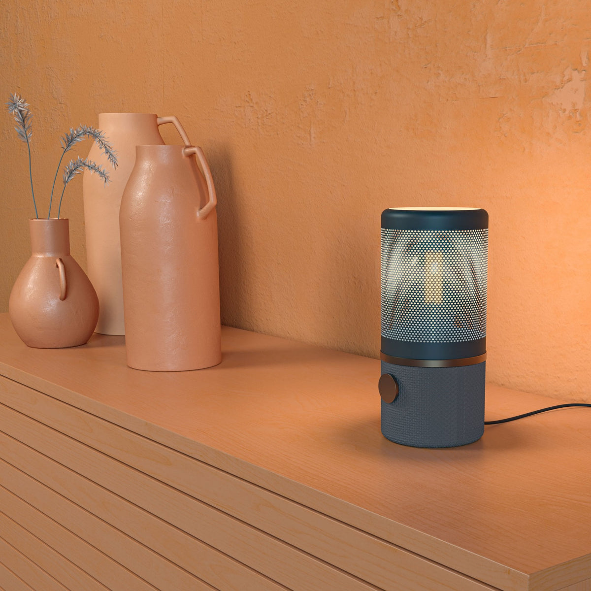 A blue humidifier on a wooden surface next to three terracotta vases.