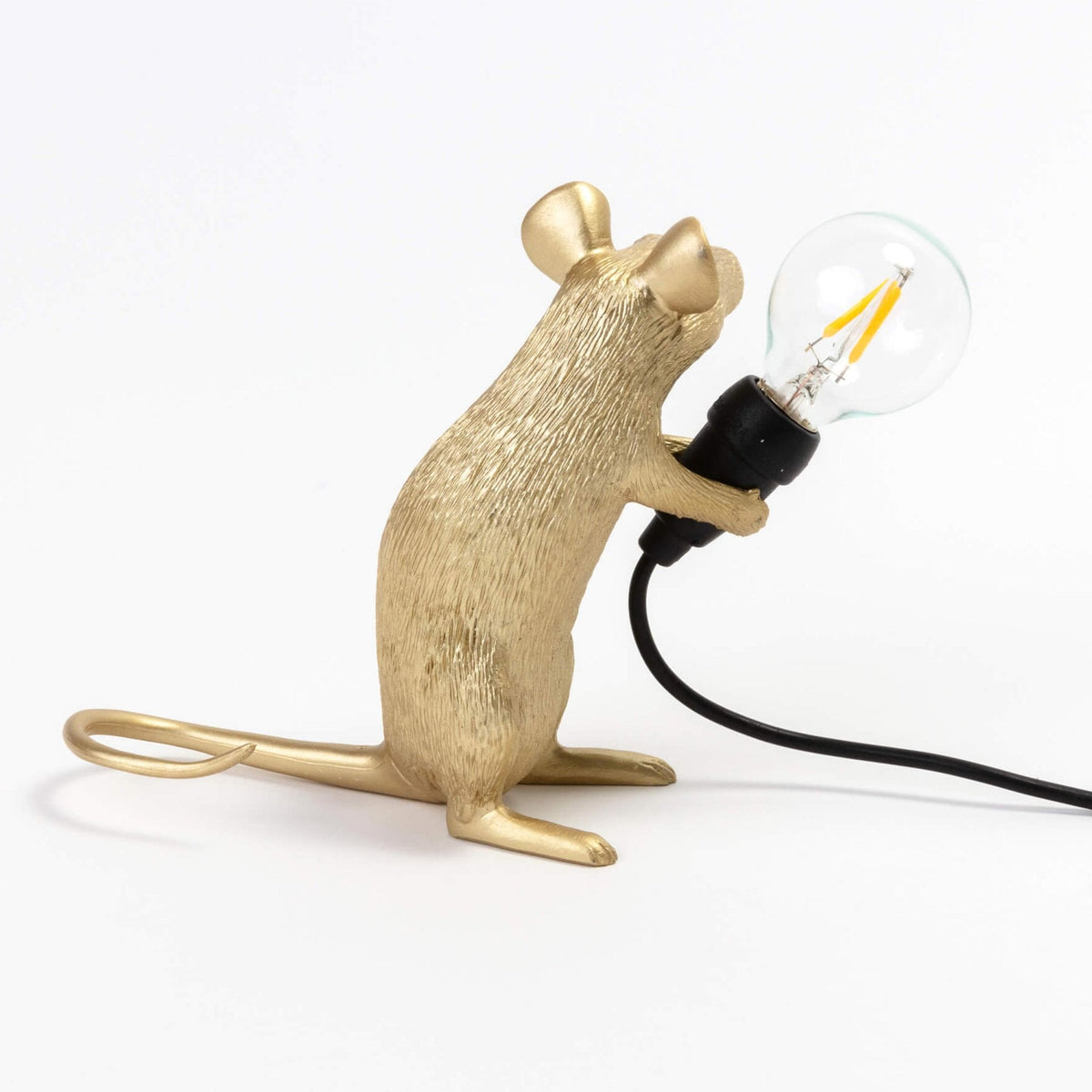 A golden mouse lamp holding a clear LED bulb, viewed from the left side.
