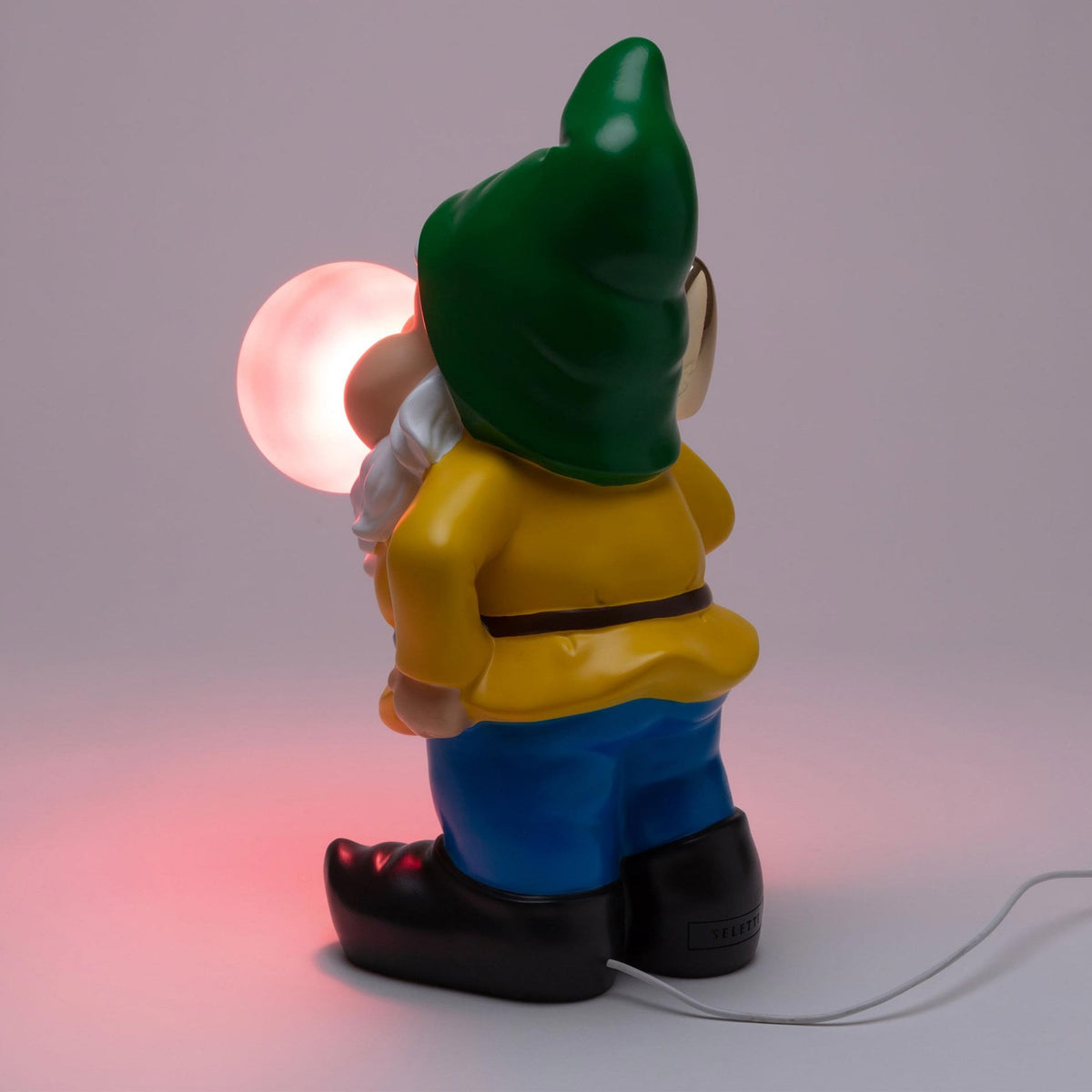 Rear view of a garden gnome blowing a white glowing bubble gum bubble.