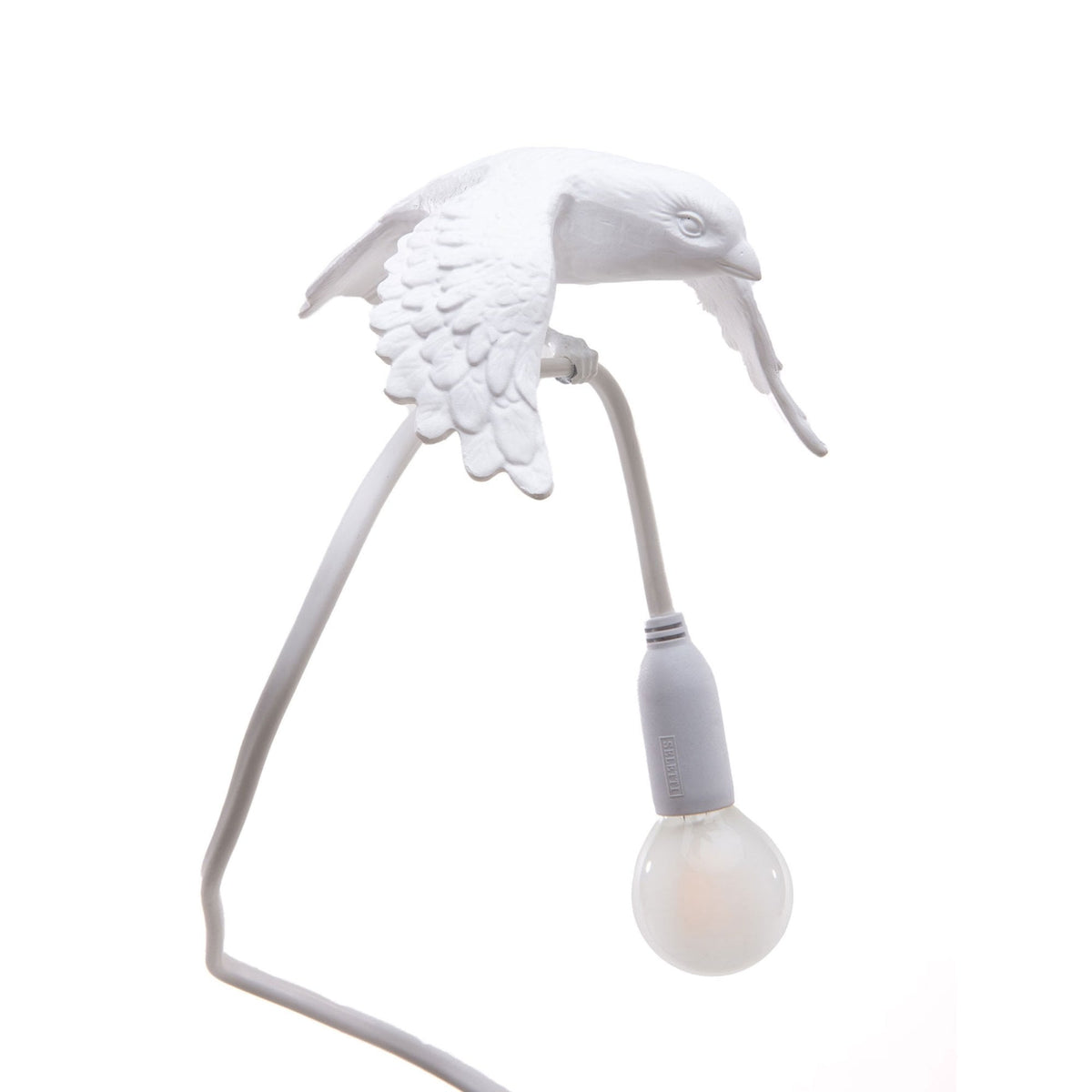 Close-up of a white bird lamp with a light bulb held in its beak against a white background.