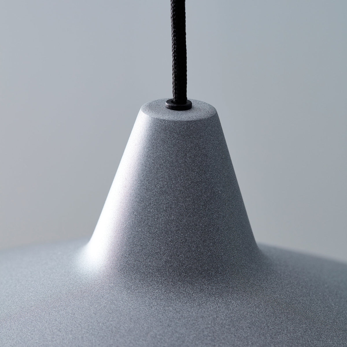 Close up of the BELID Titan Pendant in Concrete Grey, showing the textured finish and black cord