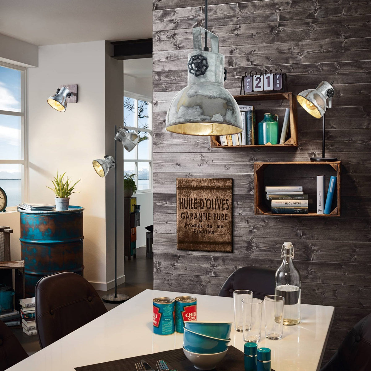 An industrial-style pendant light above a dining table in a modern, rustic-themed room.