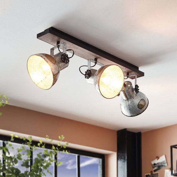Three-light ceiling spotlight with metal shades and wooden bar, two lights illuminated.