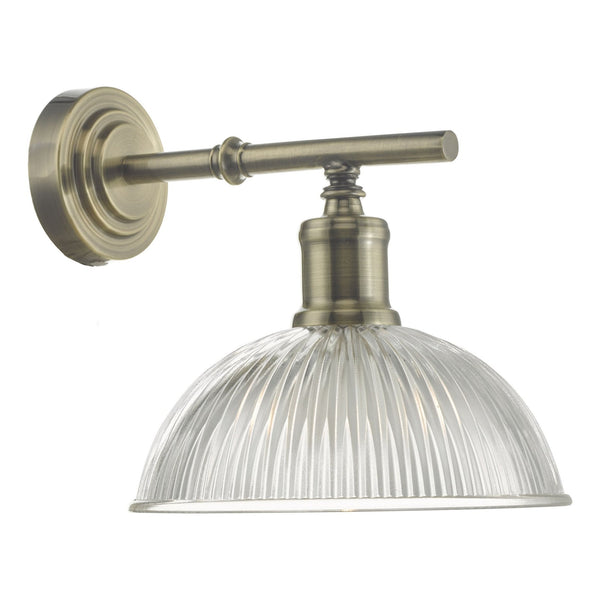 Brass wall light with clear fluted glass shade.