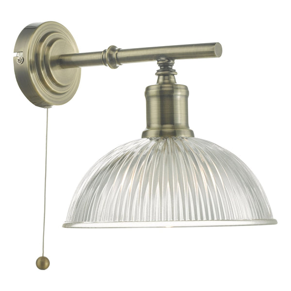 Brass wall light with clear fluted glass shade and pull cord.