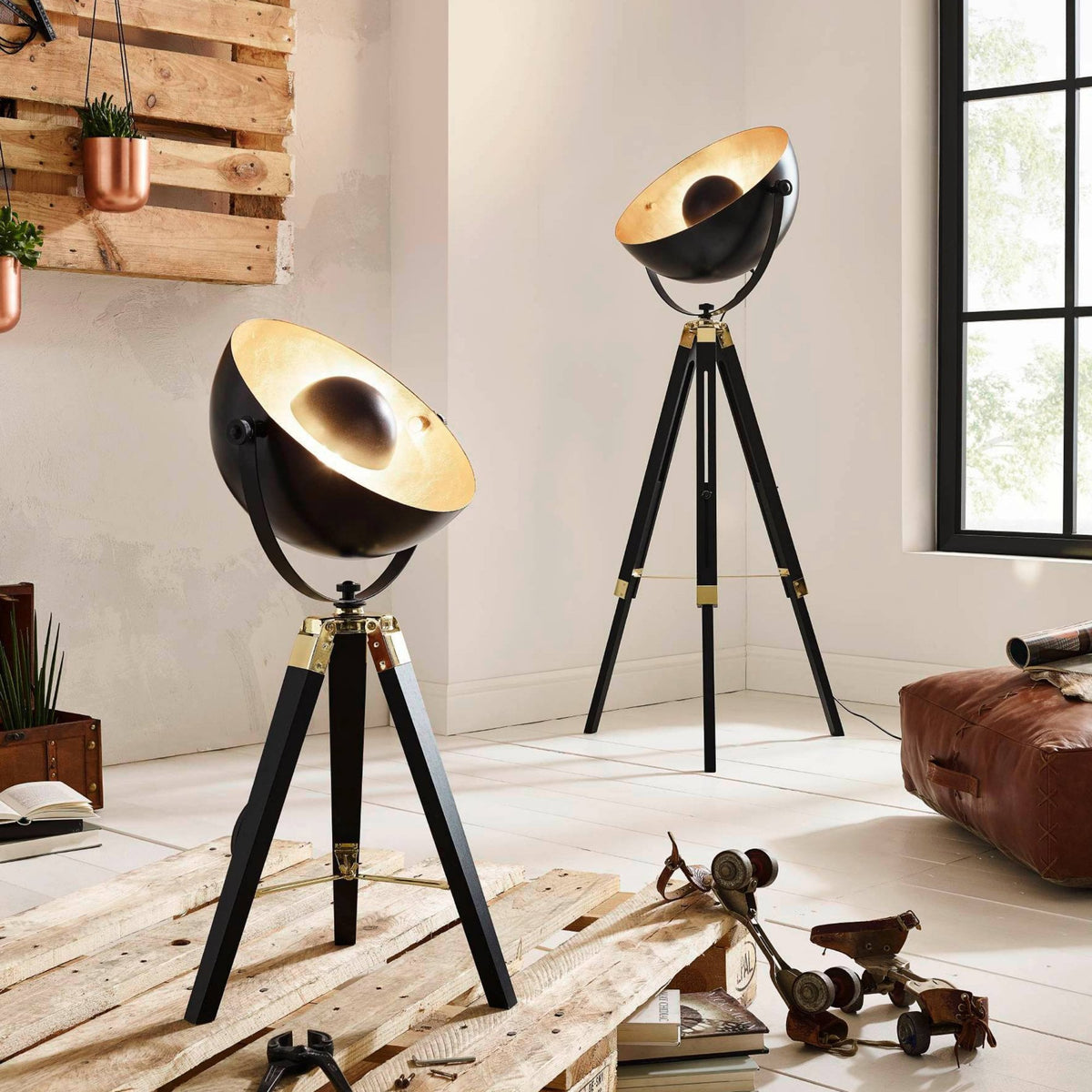 Two black and gold industrial tripod lamps, one floor lamp and one table lamp.