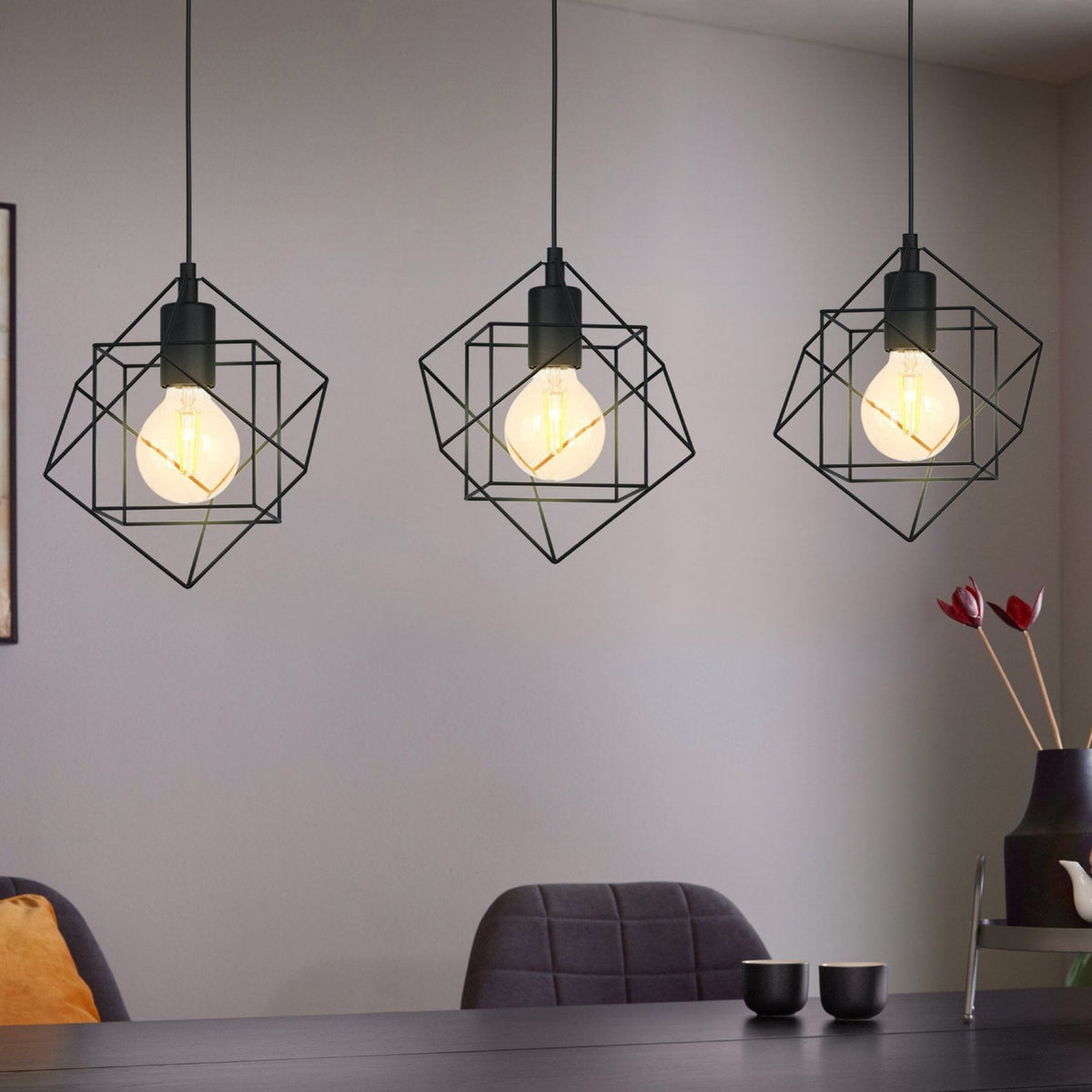 Three geometric pendant lights illuminate a dining room table.