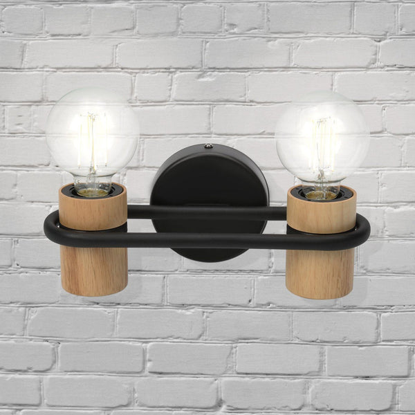 Two-light wall lamp with wooden accents and exposed bulbs on a white brick wall.