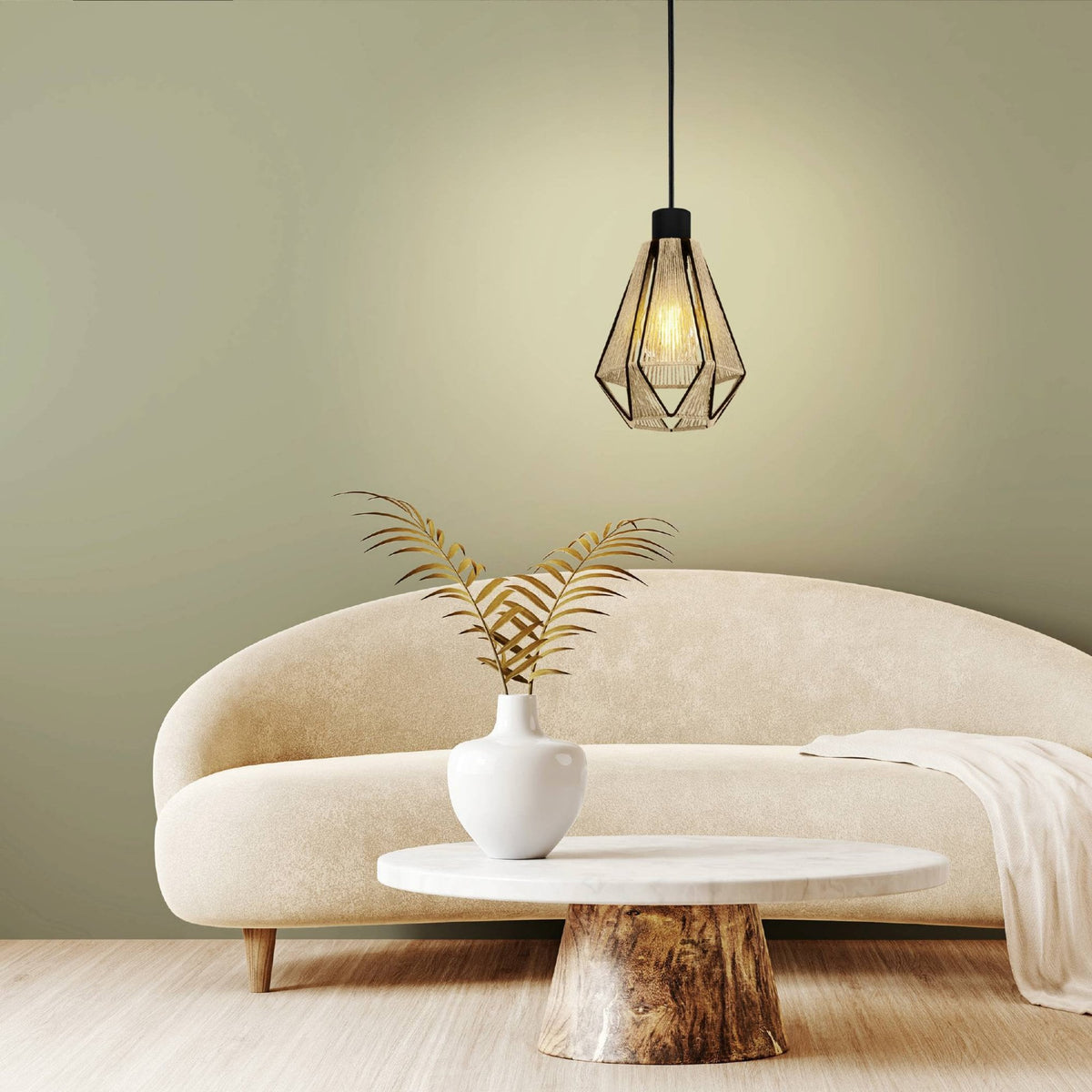 A pendant light illuminating a living room with a cream sofa and a round wooden coffee table.
