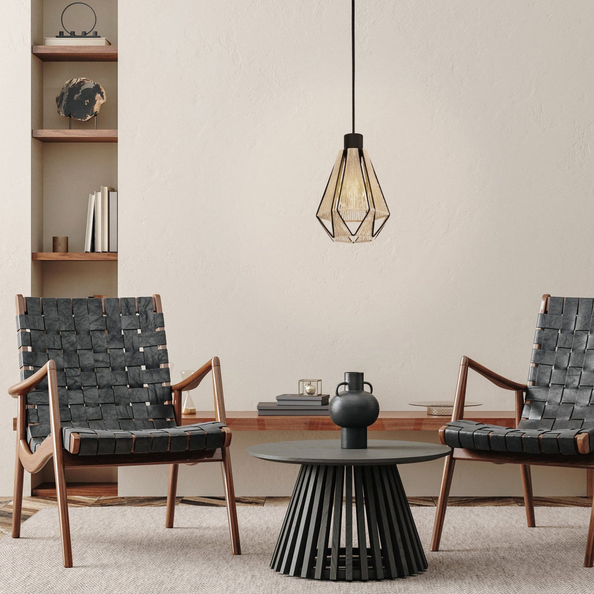 A pendant light in a modern living room setting with two woven armchairs and a coffee table.