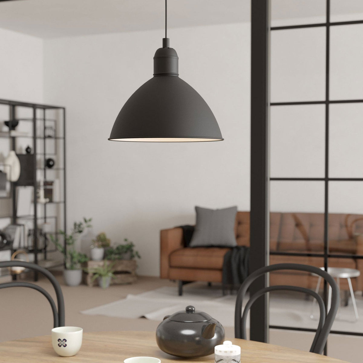 A black pendant light hangs above a wooden table in a stylish, modern room.
